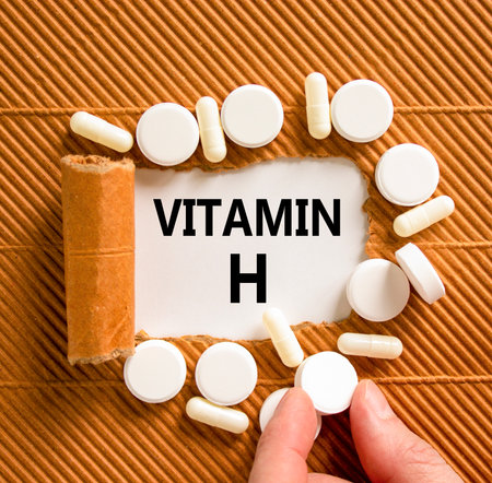 Vitamin H symbol. Concept words Vitamin H on beautiful white paper. White pills tablets. Doctor's hand. Beautiful brown background. Medical healthy lifestyle Vitamin H concept.の写真素材