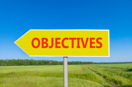 Objectives symbol. Concept words Objectives on beautiful yellow road sign. Beautiful blue sky green grass and forest peaceful nature background. Business objectives concept. Copy space.の写真素材
