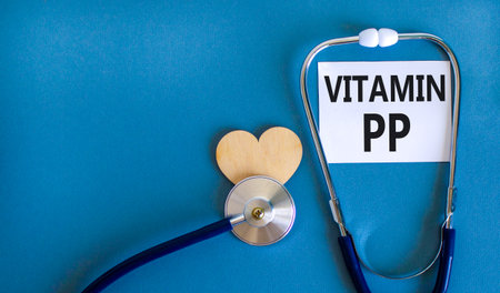 Vitamin PP symbol. Concept words Vitamin PP on beautiful white card. Wooden heart and stethoscope. Beautiful blue background. Medical healthy lifestyle Vitamin PP concept.の写真素材