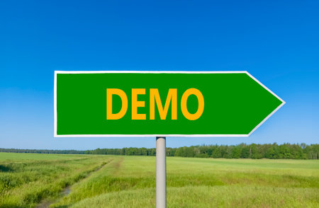 Demo symbol. Concept word Demo on beautiful green road sign. Beautiful blue sky green grass and forest peaceful nature background. Business and demo concept. Copy space.の写真素材