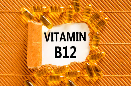 Vitamin B12 symbol. Concept words Vitamin B12 on beautiful white paper. Yellow pills tablets. Beautiful brown background. Medical healthy lifestyle Vitamin B12 concept.の写真素材