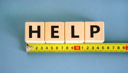 Help symbol. Concept word Help on beautiful wooden blocks. Beautiful yellow ruler. Beautiful blue table blue background. Business, lifestyle, support and help concept. Copy space.の写真素材
