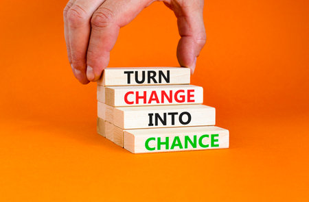 Turn change into chance symbol. Concept words phrase Turn change into chance on beautiful wooden blocks. Beautiful orange paper background. Business Turn change into chance concept. Copy space.の写真素材