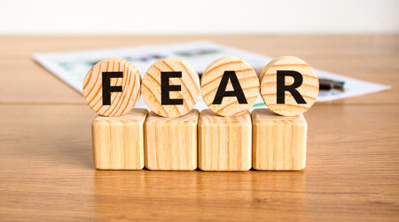 Fear symbol. Concept word Fear on beautiful wooden circles on wooden blocks. Beautiful wooden table white background. Business, lifestyle and fear concept. Copy space.の写真素材