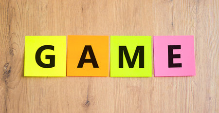 Game symbol. Concept word Game on beautiful colored paper. Beautiful wooden table wooden background. Business, lifestyle and game concept. Copy space.の写真素材