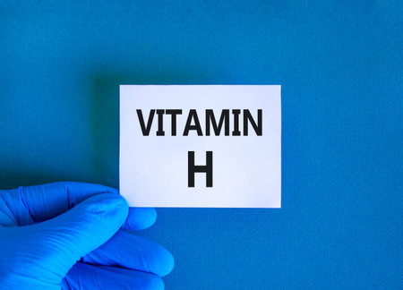 Vitamin H symbol. Concept words Vitamin H on beautiful white card. Doctor's hand in blue medical glove. Beautiful blue background. Medical healthy lifestyle Vitamin H concept.の写真素材