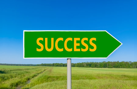 Success symbol. Concept word Success on beautiful green road sign. Beautiful blue sky green grass and forest peaceful nature background. Business success concept. Copy space.の写真素材