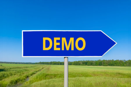 Demo symbol. Concept word Demo on beautiful blue road sign. Beautiful blue sky green grass and forest peaceful nature background. Business and demo concept. Copy space.の写真素材
