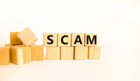 Scam symbol. Concept word Scam on beautiful wooden blocks. Beautiful white table white background....
