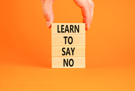 Learn to say no symbol. Concept words phrase Learn to say no on beautiful wooden blocks. Beautiful orange paper background. Businessman's hand Business psychological Learn to say no concept Copy spaceの写真素材