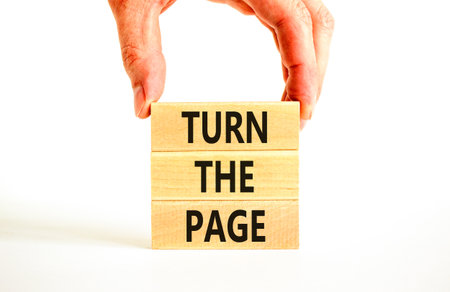 Turn the page symbol. Concept words Turn the page on beautiful wooden block. Businessman's hand. Beautiful white background. Business motivational lifestyle turn the page concept. Copy space.の写真素材