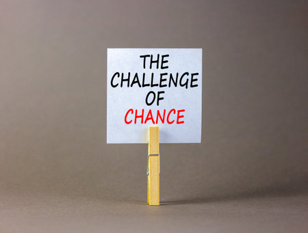 The challenge of chance symbol. Concept words phrase The challenge of chance on beautiful white paper on clothespin. Beautiful gray background. Business The challenge of chance concept. Copy space.の写真素材