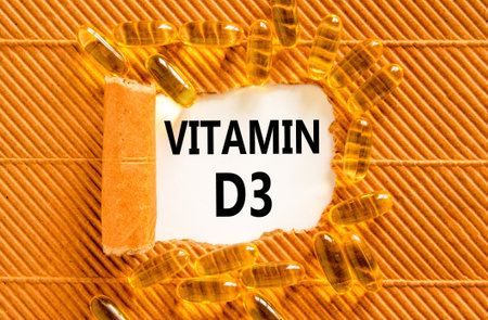 Vitamin D3 symbol. Concept words Vitamin D3 on beautiful white paper. Yellow pills tablets. Beautiful brown background. Medical healthy lifestyle Vitamin D3 concept.の写真素材