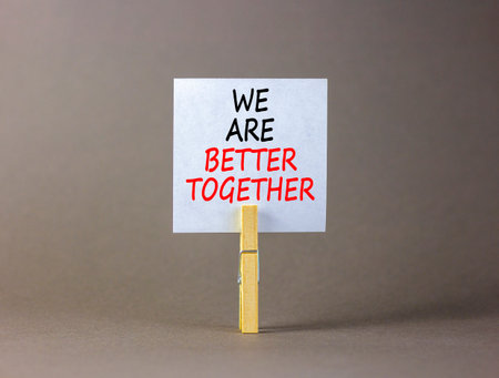 We are better together symbol. Concept words phrase We are better together on beautiful white paper on clothespin. Beautiful gray background. Business We are better together concept. Copy space.の写真素材