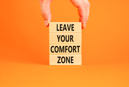Leave your comfort zone symbol. Concept words Leave your comfort zone on beautiful wooden blocks. Beautiful orange paper background. Business psychological Leave your comfort zone concept. Copy space.の写真素材