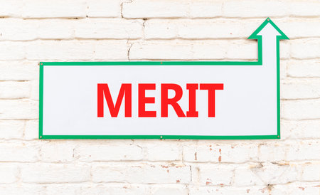 Merit symbol. Concept word Merit on beautiful white sign on old white brick wall. Beautiful brick old white wall background. Business lifestyle merit concept. Copy space.の写真素材