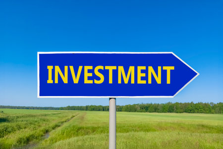 Investment symbol. Concept word Investment on beautiful blue road sign. Beautiful blue sky green...