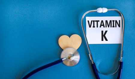 Vitamin K phylloquinone symbol. Concept words Vitamin K on beautiful white card. Wooden heart and...