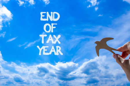 End of tax year symbol. Concept words phrase End of tax year on beautiful blue sky. Businessman's...