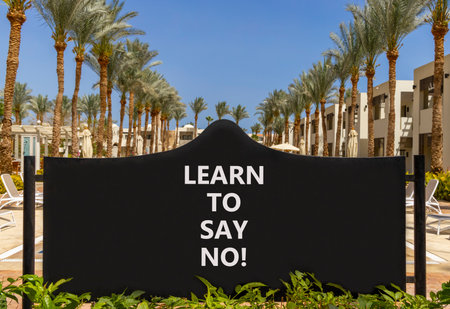 Learn to say no symbol. Concept words phrase Learn to say no on beautiful big black road sign. Beautiful palm tree blue sky background. Business psychological Learn to say no concept. Copy space.の写真素材