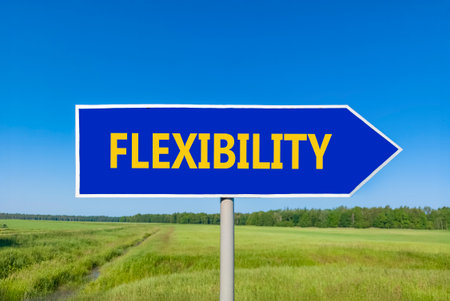 Flexibility symbol. Concept word Flexibility on beautiful blue road sign. Beautiful blue sky green grass and forest peaceful nature background. Business flexibility concept. Copy space.の写真素材