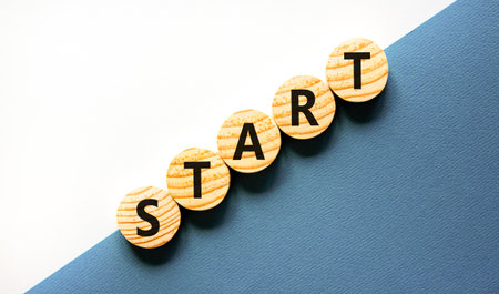Start symbol. Concept word Start on beautiful wooden circles. Beautiful white and blue background....