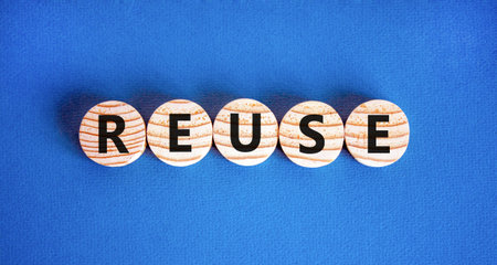 Reuse symbol. Concept word Reuse on beautiful wooden circles. Beautiful blue table blue background....