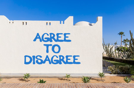 Agree to disagree symbol. Concept words Agree to disagree on beautiful white wall. Beautiful white wall blue sky background. Business and agree to disagree concept. Copy space.の写真素材