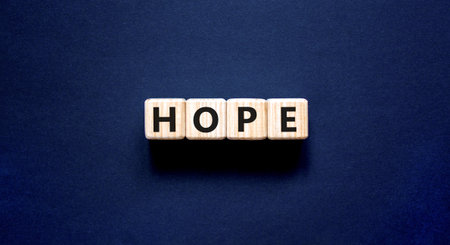 Hope symbol. Concept word Hope on beautiful wooden blocks. Beautiful black table black background....