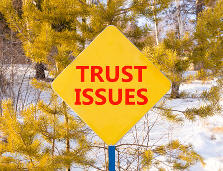 Trust issues symbol. Concept word Trust issues on beautiful yellow road sign. Beautiful snow winter...