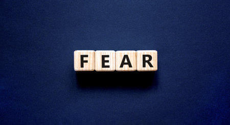 Fear symbol. Concept word Fear on beautiful wooden blocks. Beautiful black table black background. Business, lifestyle and fear concept. Copy space.の写真素材