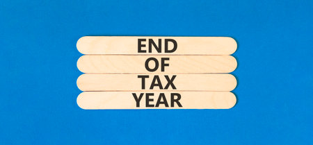 End of tax year symbol. Concept words phrase End of tax year on beautiful wooden stick. Beautiful...