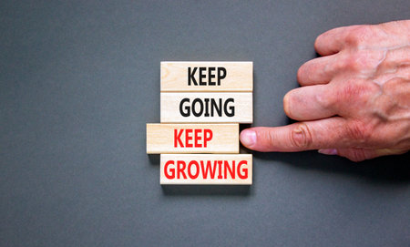 Keep going and growing symbol. Concept words phrase Keep going keep growing on beautiful wooden...