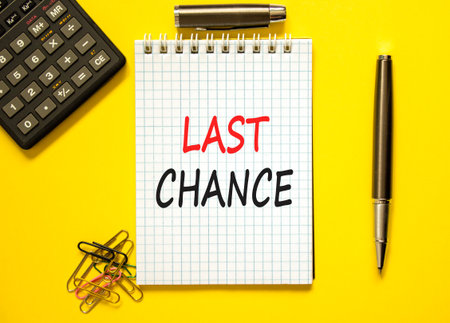 Last chance symbol. Concept word Last chance on beautiful white note. Black calculator. Black pen. Beautiful yellow paper background. Business last chance concept. Copy space.