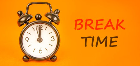 Break time symbol. Concept Break word time on beautiful orange paper. Beautiful black alarm clock. Beautiful orange paper background. Business break time concept. Copy space.の写真素材