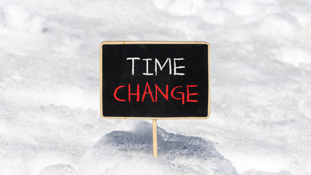 Time change symbol. Concept word Time change on beautiful black blackboard. Beautiful white snow background. White snow. Black blackboard. Business time change concept. Copy space.の写真素材