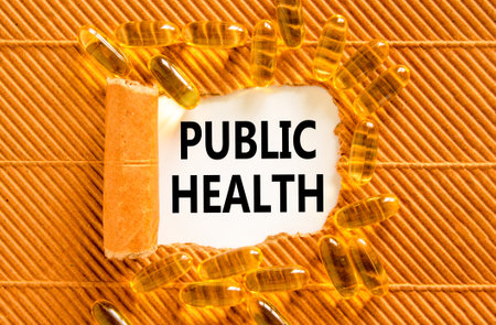 Public health symbol. Concept words Public health on beautiful white paper. Yellow pills tablets. Beautiful brown background. Medical healthy lifestyle public health concept.の写真素材