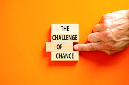 The challenge of chance symbol. Concept words phrase The challenge of chance on beautiful wooden blocks. Beautiful orange paper background. Business The challenge of chance concept. Copy space.の写真素材