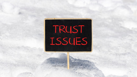 Trust issues symbol. Concept word Trust issues on beautiful black blackboard. Beautiful white snow...