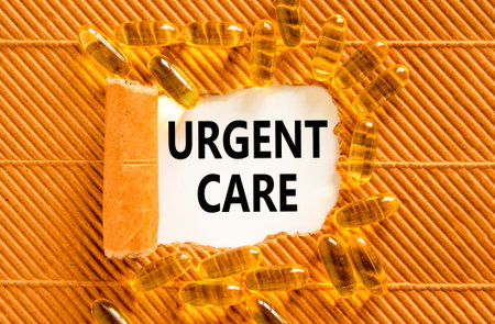 Urgent care symbol. Concept words Urgent care on beautiful white paper. Yellow pills tablets. Beautiful brown background. Medical healthy lifestyle urgent care concept.の写真素材