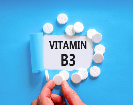 Vitamin B3 niacin symbol. Concept words Vitamin B3 on beautiful white paper. White pills tablets. Doctor's hand. Beautiful blue background. Medical healthy lifestyle Vitamin B3 niacin concept.の写真素材