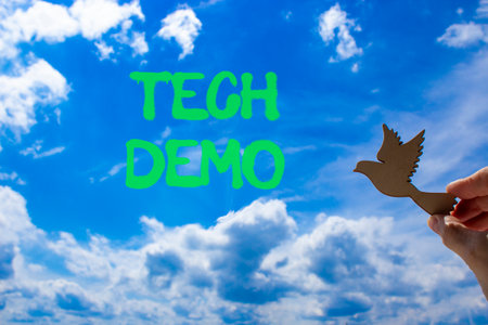 Tech demo symbol. Concept word Tech demo on beautiful blue sky. Businessman's hand with wooden bird. Beautiful blue sky and cloud background. Business tech demo concept. Copy space.の写真素材