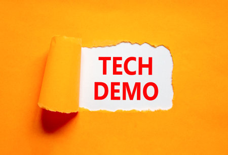 Tech demo symbol. Concept word Tech demo on beautiful white paper. Beautiful orange paper background. Business tech demo concept. Copy space.の写真素材