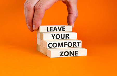 Leave your comfort zone symbol. Concept words Leave your comfort zone on beautiful wooden blocks. Beautiful orange paper background. Business psychological Leave your comfort zone concept. Copy space.の写真素材