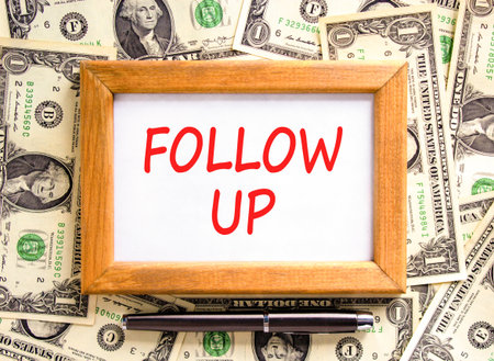 Follow up symbol. Concept word Follow up on beautiful wooden picture frame. Dollar bills. Beautiful...