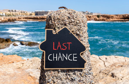 Last chance symbol. Concept word Last chance on beautiful black blackboard. Beautiful stone and blue sea sky background. Black blackboard. Business last chance concept. Copy space.