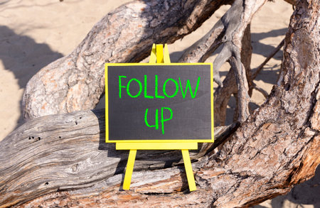 Follow up symbol. Concept word Follow up on beautiful black blackboard. Beautiful old tree background. Black blackboard. Business follow up concept. Copy space.の写真素材