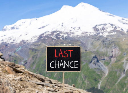 Last chance symbol. Concept word Last chance on beautiful black blackboard. Beautiful stone mountain Elbrus blue sky background. Black blackboard. Business last chance concept. Copy space.の写真素材
