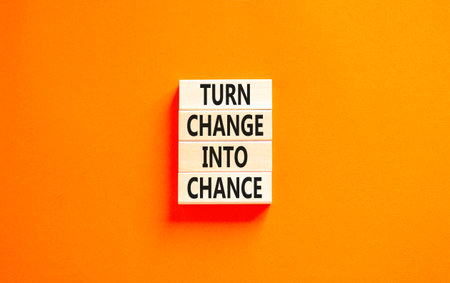 Turn change into chance symbol. Concept words phrase Turn change into chance on beautiful wooden blocks. Beautiful orange paper background. Business Turn change into chance concept. Copy space.の写真素材
