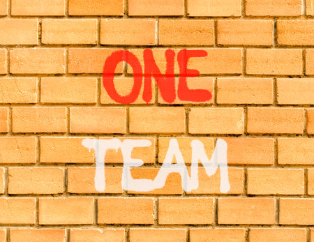 One team symbol. Concept word One team on beautiful brown brick wall. Beautiful brown brick wall background. Brick wall Business one team concept. Copy space.の写真素材
